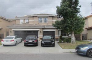 Three cars parked in front of house.