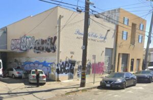 Auto body shop with graffiti and cars.