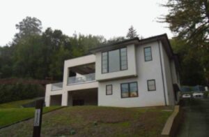 Modern white house with large windows.