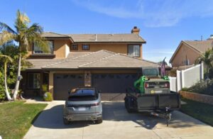 A two-story house with a car and a trailer.