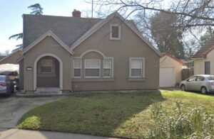 A brown house with a front yard and driveway.