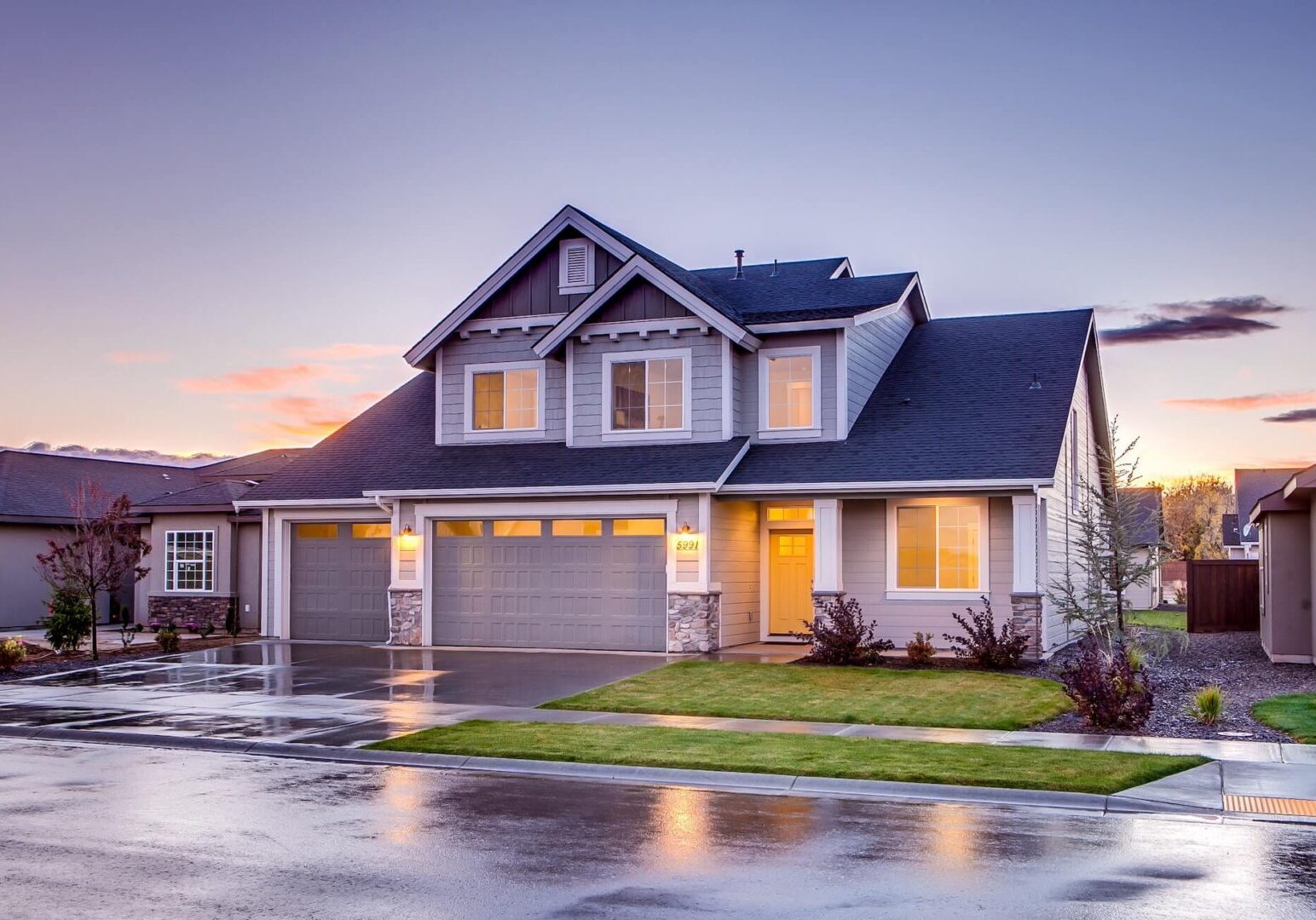 A house with a driveway and grass in front of it.